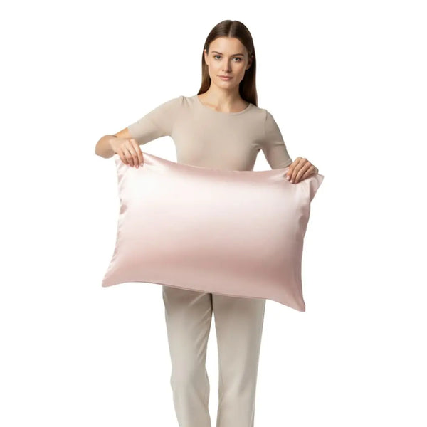 Mannequin debout tenant un oreiller avec une taie en soie rose pâle