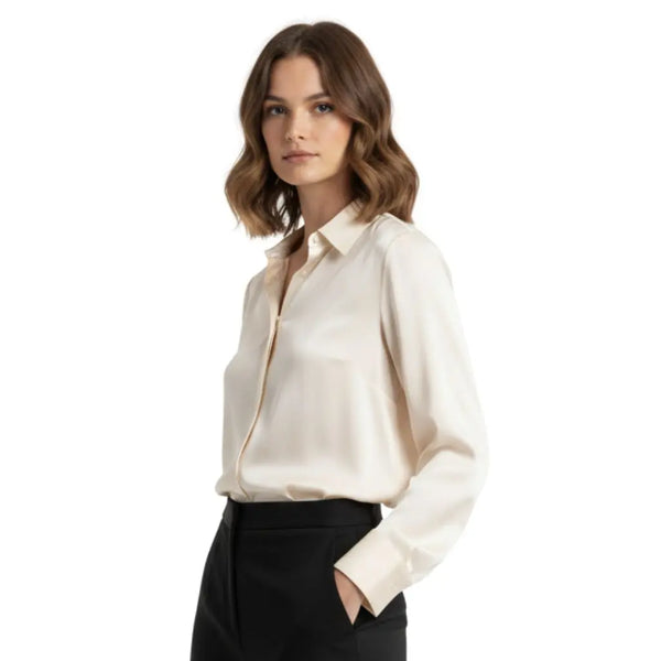 Mannequin légèrement tournée qui porte une chemise en soie crème et un pantalon noir