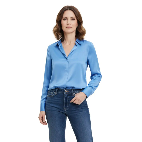 Mannequin de face portant une chemise en satin bleu et un jean
