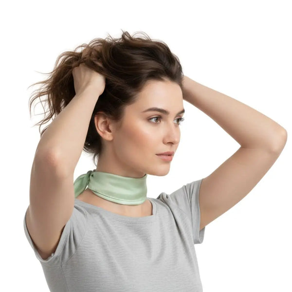 Mannequin mains dans les cheveux avec un foulard en soie vert pastel autour du cou