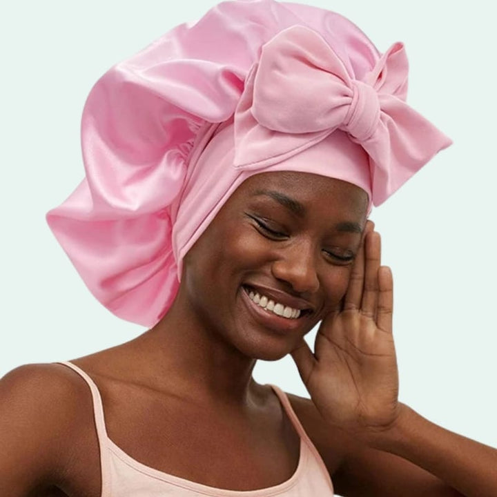 Modèle portant un bonnet de nuit brillant extensible en satin rose