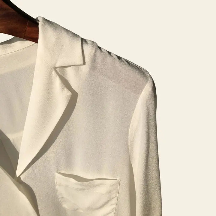 Zoom sur l'épaule d'une chemise élégante vintage en crêpe de chine en soie blanche