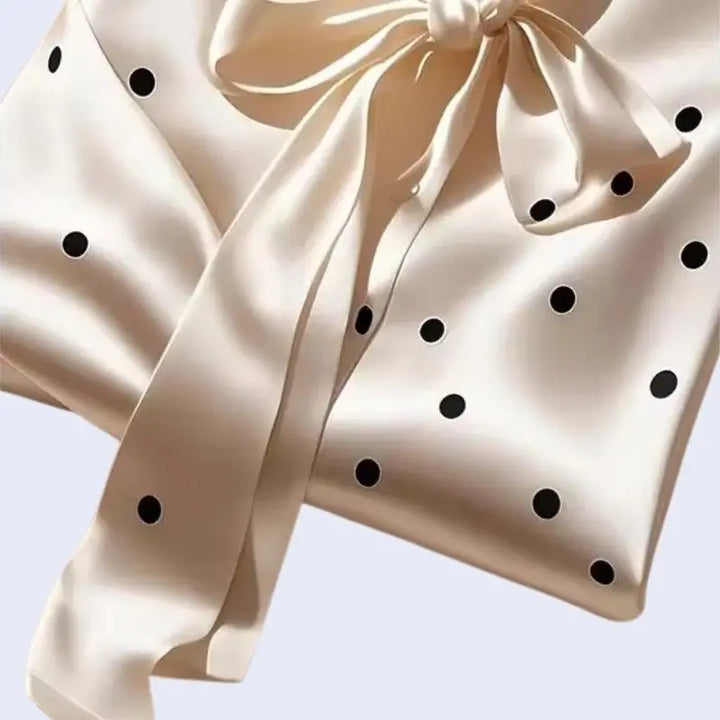 Zoom sur le ruban d'une chemise manches longues à pois col foulard en satin ivoire