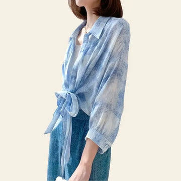 Modèle portant un chemisier fluide bleu ciel à noeud en soie de mûrier