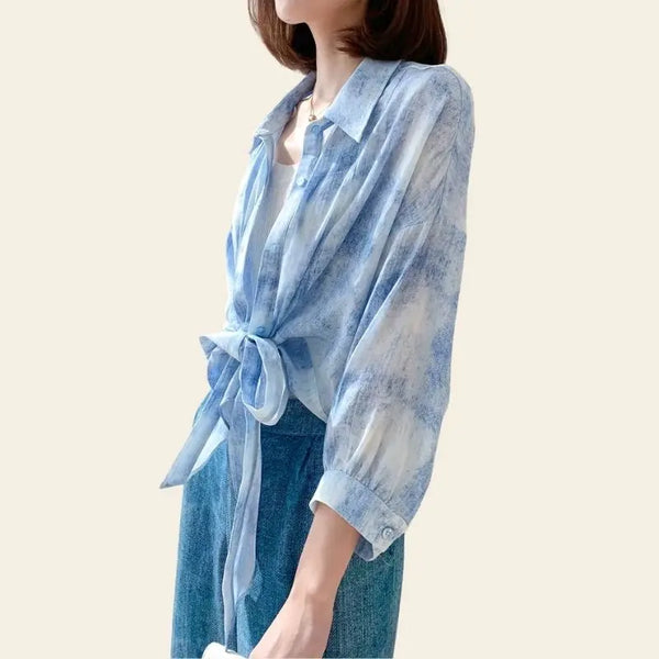 Modèle portant un chemisier fluide bleu ciel à noeud en soie de mûrier