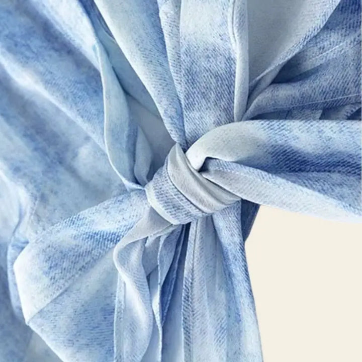 Zoom sur le nœud du chemisier fluide bleu ciel à noeud en soie de mûrier