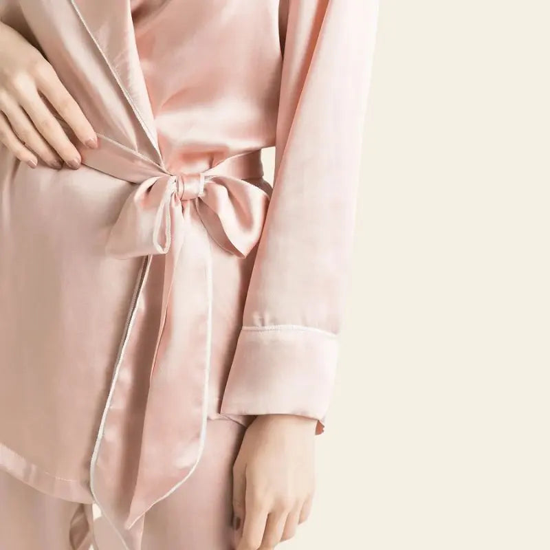 Zoom sur la manche d'un ensemble peignoir et pantalon rose en soie de mûrier