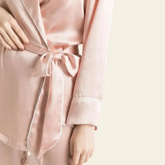 Zoom sur la manche d'un ensemble peignoir et pantalon rose en soie de mûrier