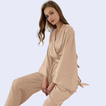 Mannequin assise portant un ensemble chemise avec ceinture et pantalon style oversize couleur champagne