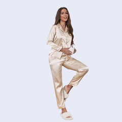 Mannequin portant un ensemble pyjama chemisier long boutonné et pantalon en satin brillant couleur beige
