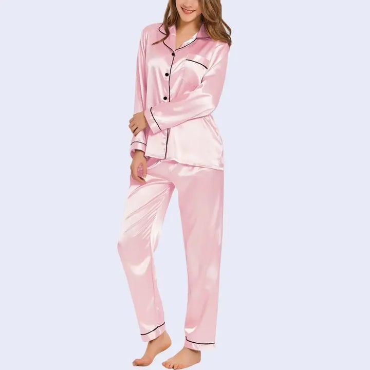 Mannequin portant un ensemble pyjama chemisier long boutonné et pantalon en satin brillant couleur rose