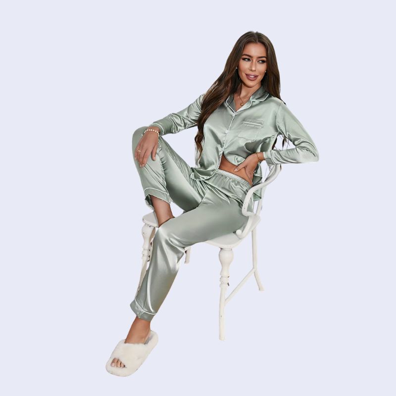 Mannequin assis portant un ensemble pyjama chemisier long boutonné et pantalon en satin brillant couleur vert celadon