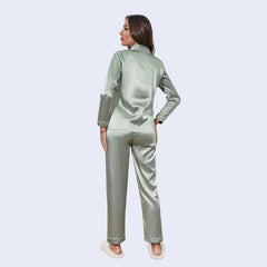 Mannequin de dos portant un ensemble pyjama chemisier long boutonné et pantalon en satin brillant couleur vert celadon