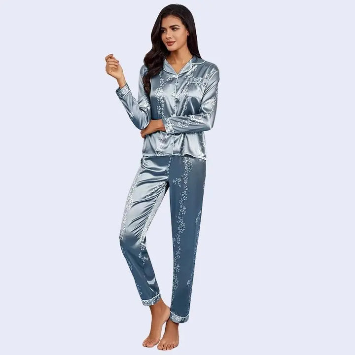 Mannequin brune portant un ensemble pyjama chemisier long et pantalon motifs floraux en satin couleur bleu acier