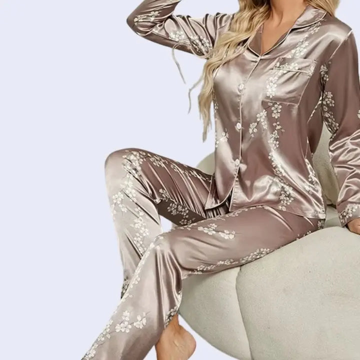 Mannequin assis portant un ensemble pyjama chemisier long et pantalon motifs floraux en satin couleur chocolat