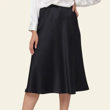 Modèle de profil portant une jupe brillante mi-longue en soie de mûrier couleur noire