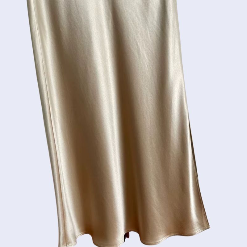 Zoom sur une jupe longue fendue élastique et élégante en satin beige