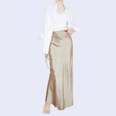 Modèle portant une jupe longue unie texturée en satin couleur champagne
