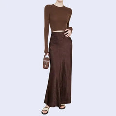 Modèle portant une jupe longue unie texturée en satin couleur chocolat