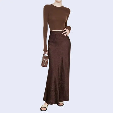 Modèle portant une jupe longue unie texturée en satin couleur chocolat