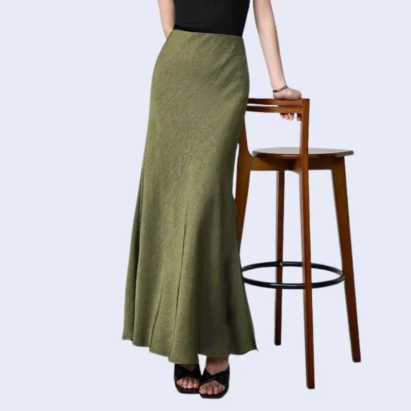 Modèle portant une jupe longue unie texturée en satin couleur kaki