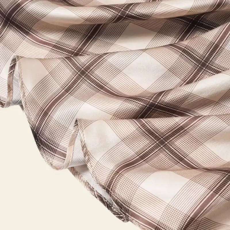 Zoom sur une jupe mi-mollet motif tartan beige en soie véritable
