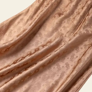 Zoom sur le tissu de la jupe mi-mollet motif Paisley en soie véritable camel