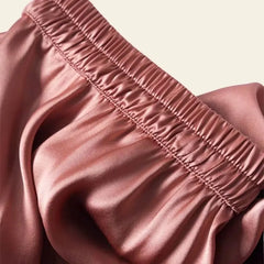 Zoom sur une jupe plissée unie effet satiné en soie véritable couleur corail