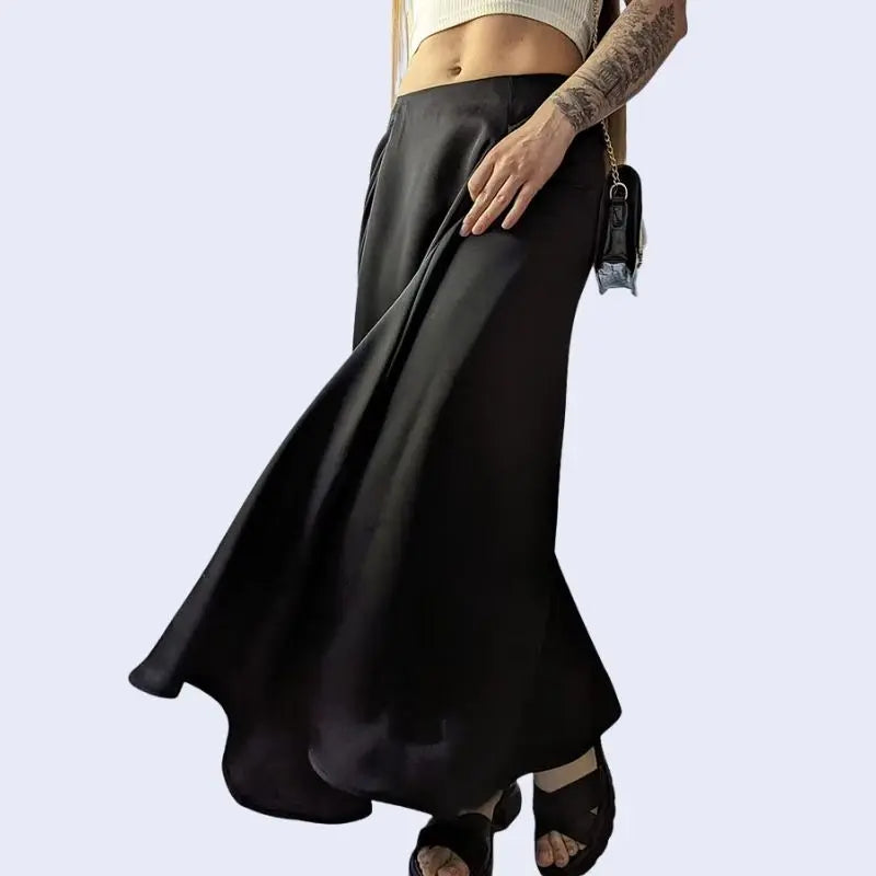 Mannequin tatouée portant une jupe maxi trapèze brillante décontractée en satin noire