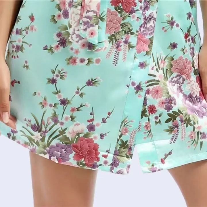 Zoom sur le bas d'un kimono court brillant imprimé floral en satin couleur vert menthe
