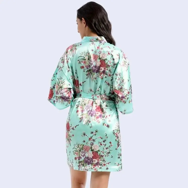 Mannequin de dos portant un kimono court brillant imprimé floral en satin couleur vert menthe