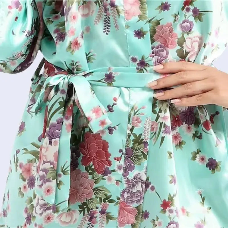 Zoom sur le haut d'un kimono court brillant imprimé floral en satin couleur vert menthe