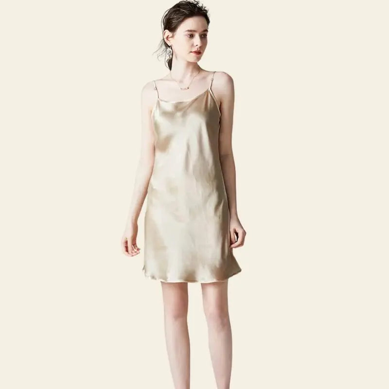 Modèle de face portant une mini-robe brillante à bretelles fines 100% soie couleur champagne