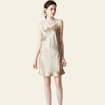 Modèle de face portant une mini-robe brillante à bretelles fines 100% soie couleur champagne