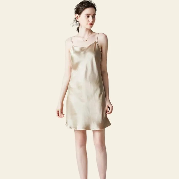 Modèle de face portant une mini-robe brillante à bretelles fines 100% soie couleur champagne