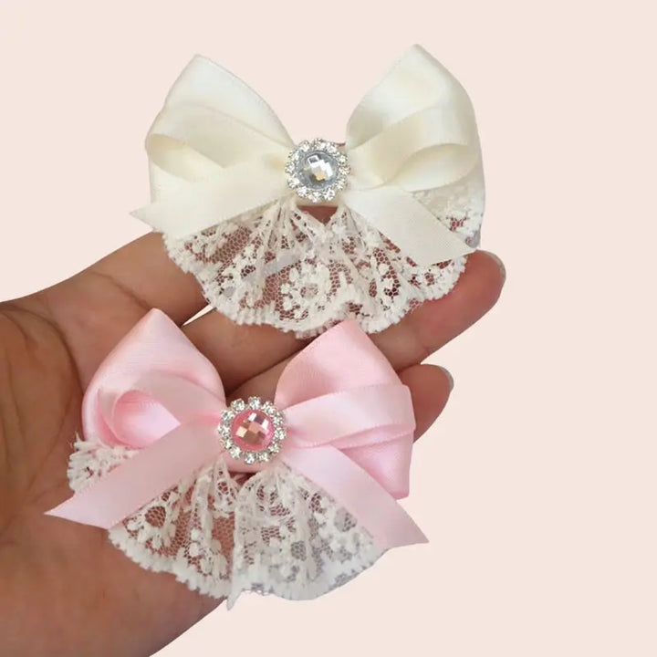 Main tenant des nœuds rubans en satin et dentelle ivoire et rose pastel