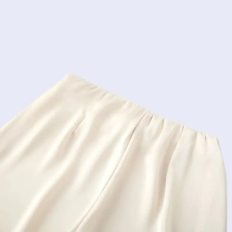 Zoom sur le haut d'un pantalon droit ivoire décontracté en satin