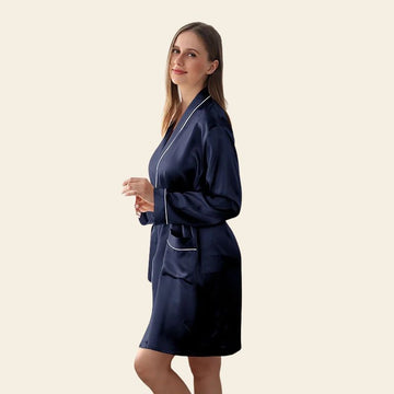 Mannequin de profil portant un peignoir court manches longues avec liseré blanc en soie de mûrier bleu marine