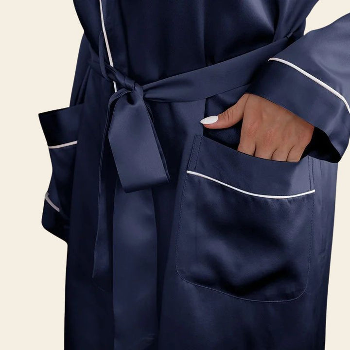 Zoom sur les poches d'un peignoir court manches longues avec liseré blanc en soie de mûrier bleu marine