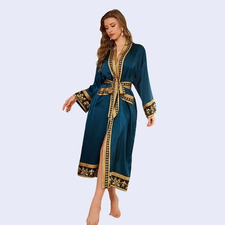 Mannequin regardant le sol portant un peignoir oriental avec motifs dorés en satin couleur bleu canard
