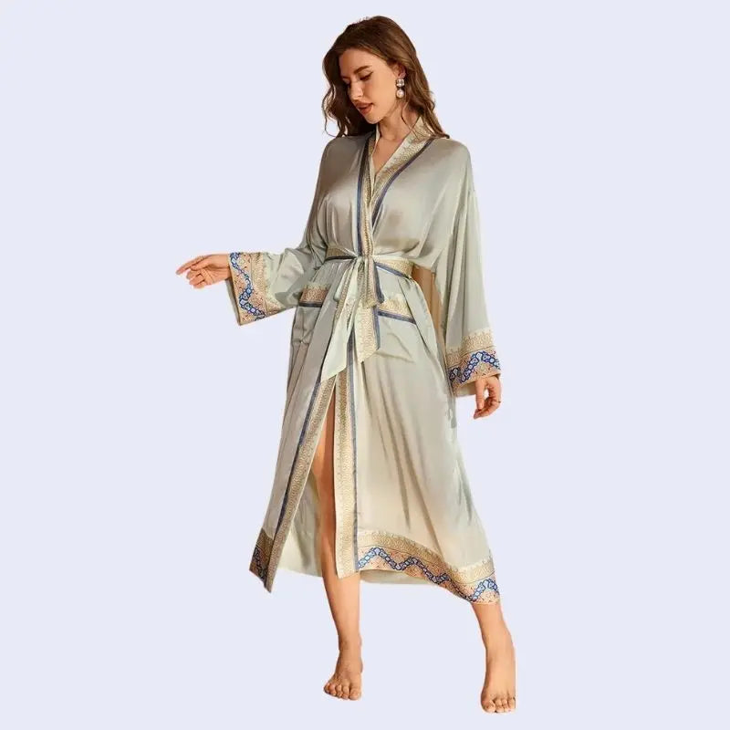 Mannequin regardant le sol portant un peignoir oriental avec motifs dorés en satin couleur gris clair