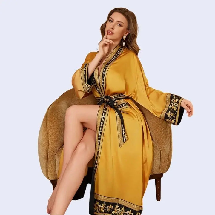 Mannequin assise portant un peignoir oriental avec motifs dorés en satin couleur jaune