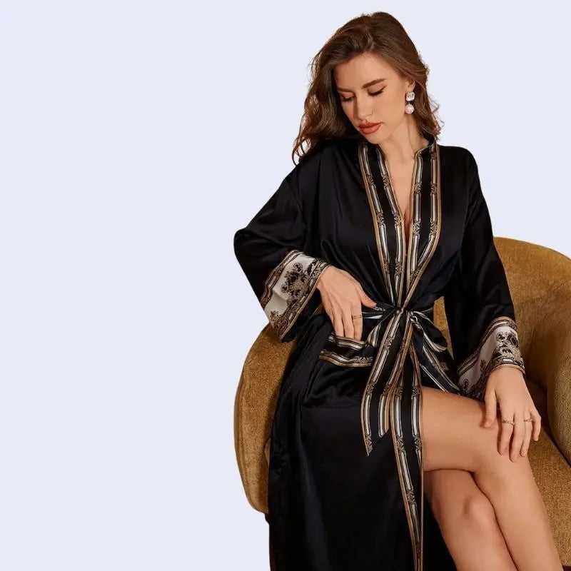 Mannequin assise portant un peignoir oriental avec motifs dorés en satin couleur noire