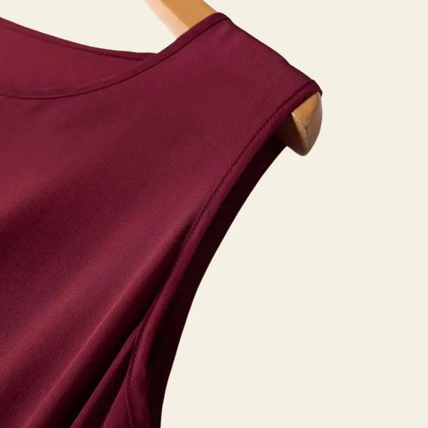 Zoom sur l'épaule d'une robe bordeaux longue sans manches évasée en soie de mûrier