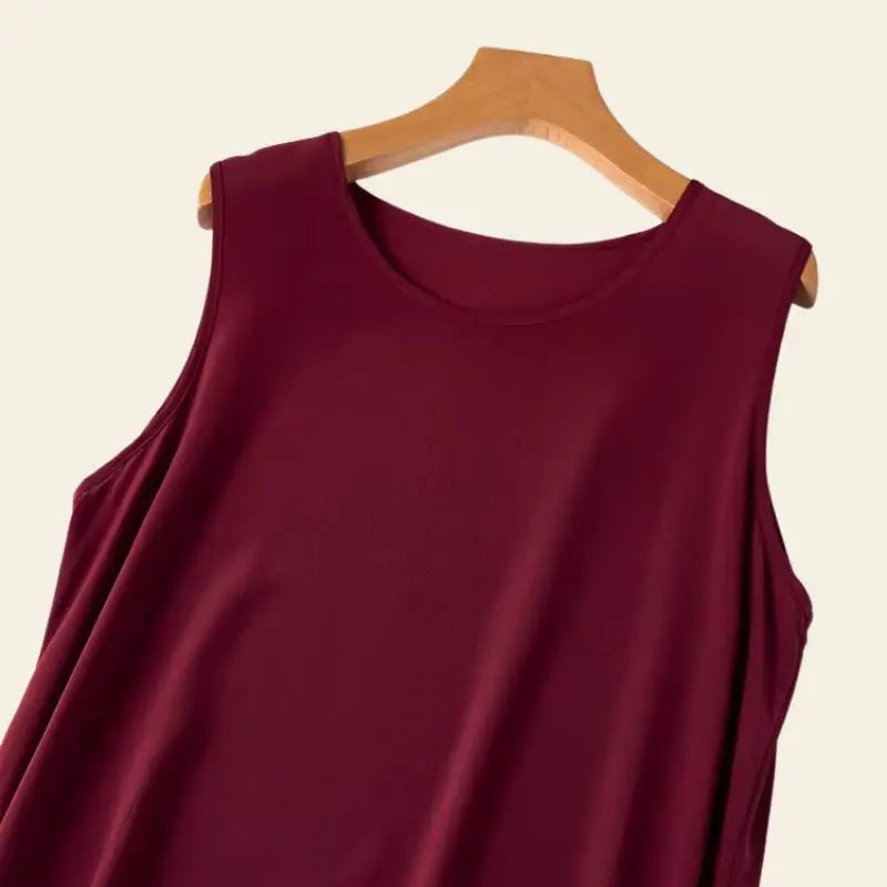 Zoom sur le haut d'une robe bordeaux longue sans manches évasée en soie de mûrier