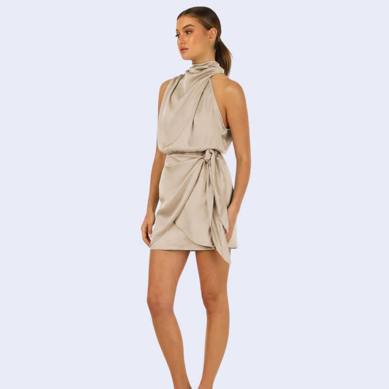 Mannequin de profil portant une robe courte sans manches col montant en satin couleur beige