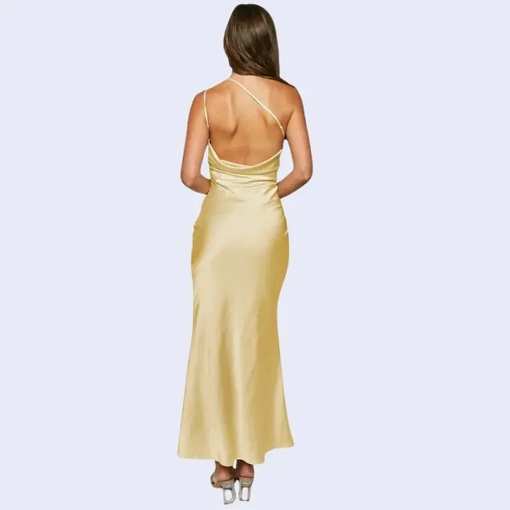 Femme de dos portant une robe longue asymétrique en satin jaune
