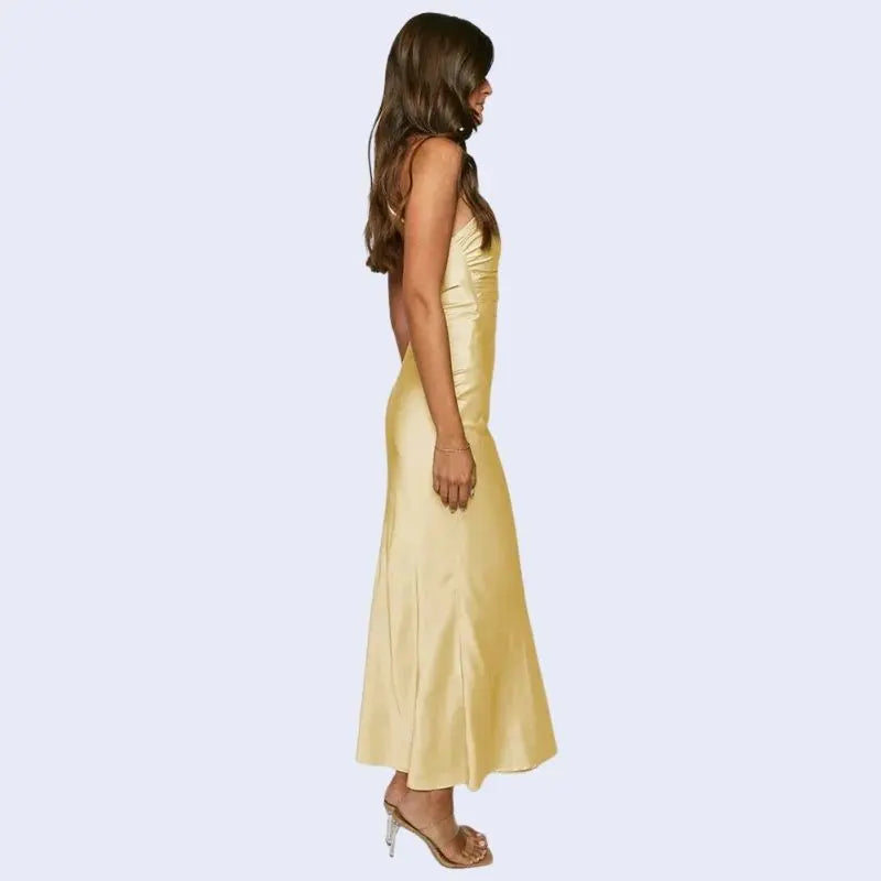 Femme de profil portant une robe longue asymétrique en satin jaune