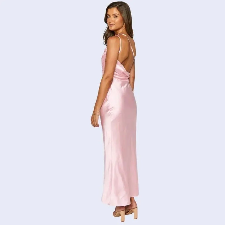 Femme de dos portant une robe longue asymétrique en satin rose