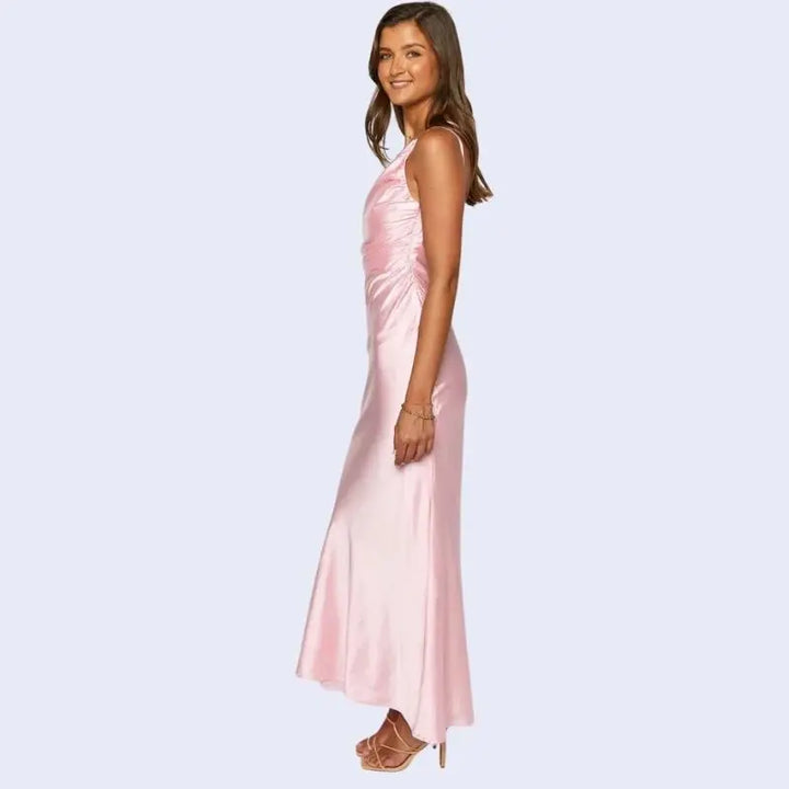 Femme de profil portant une robe longue asymétrique en satin rose